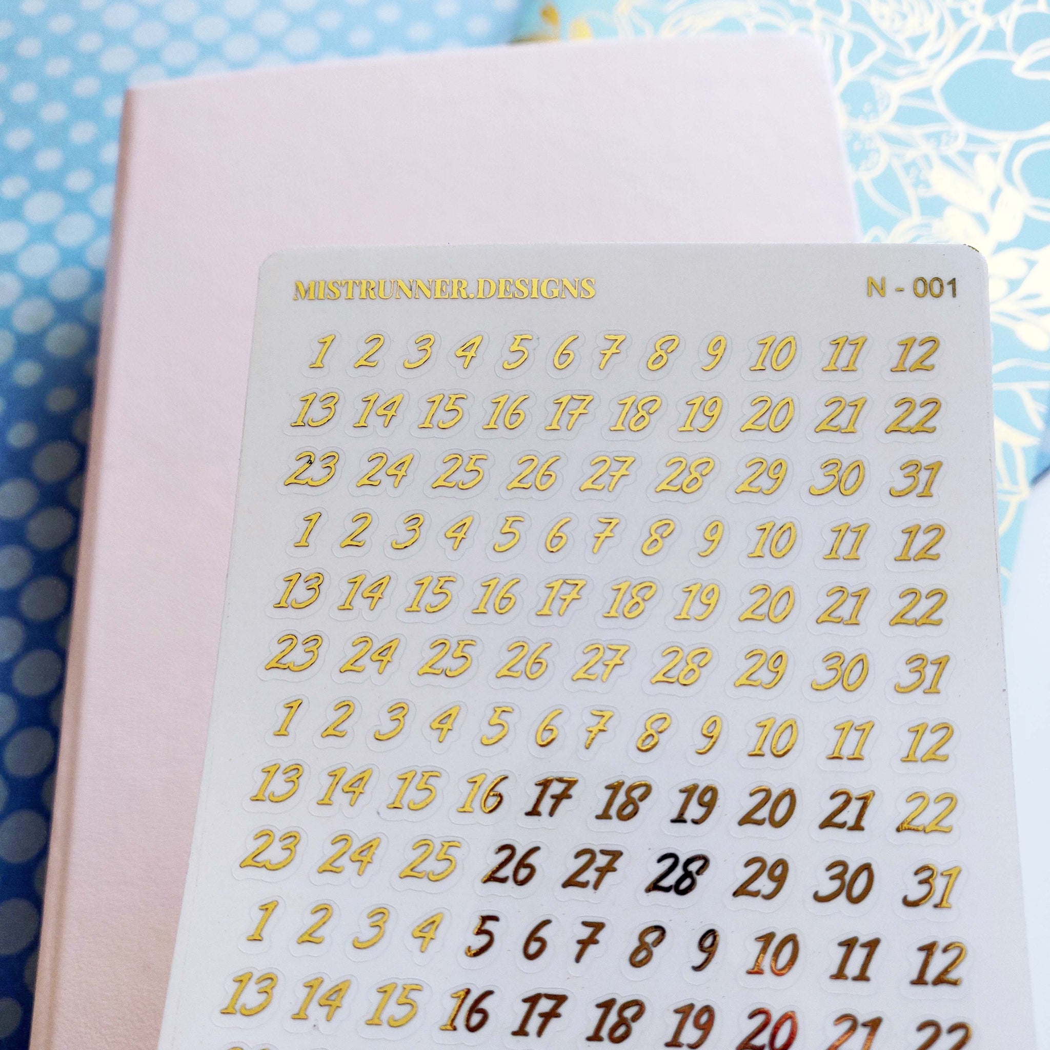 foiled sheet with number date cover planner stickers on a clear background
